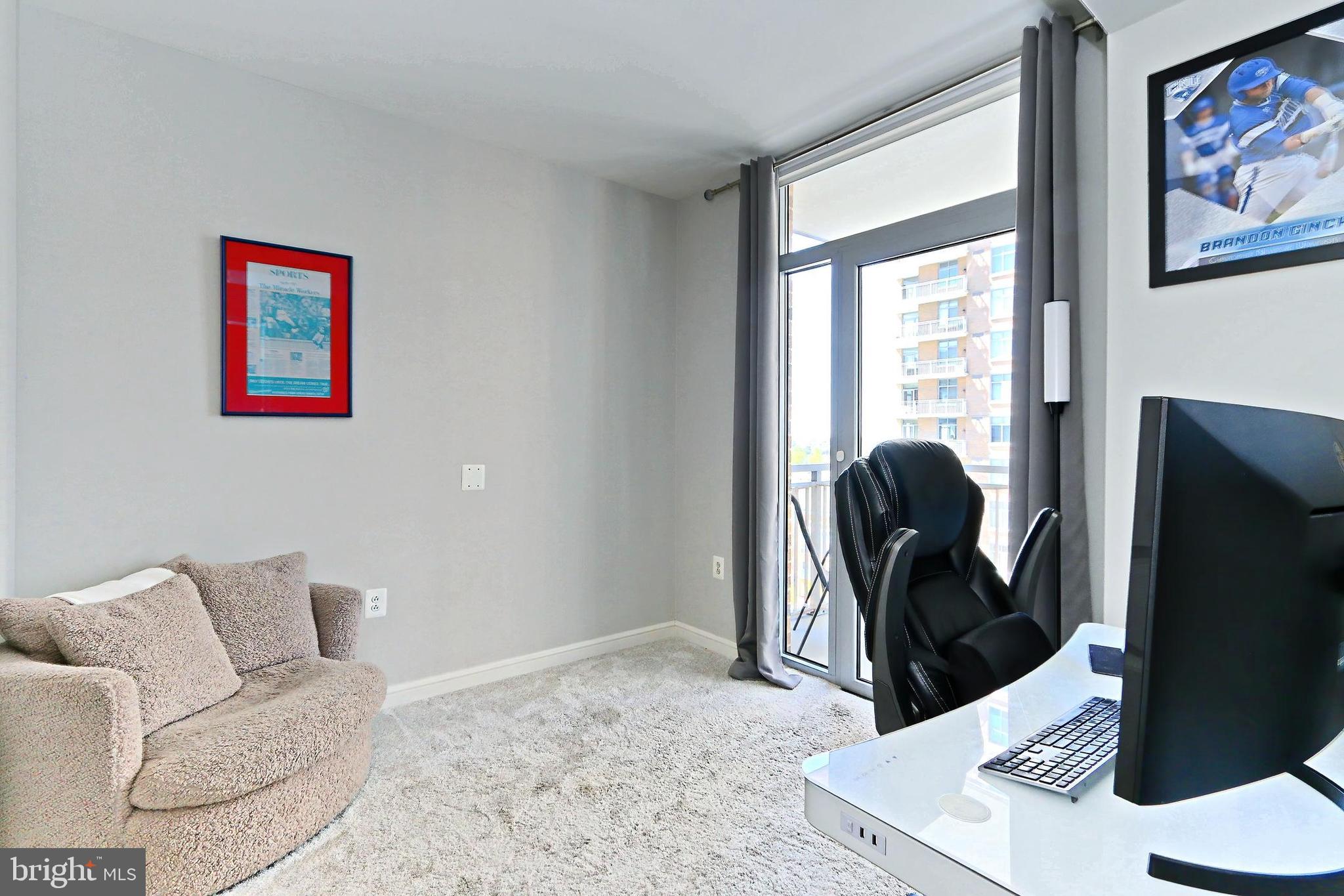 11990 Market Street, Unit 908 Reston, VA 20190 - Photo 17 of 45 a living room with furniture and a flat screen tv