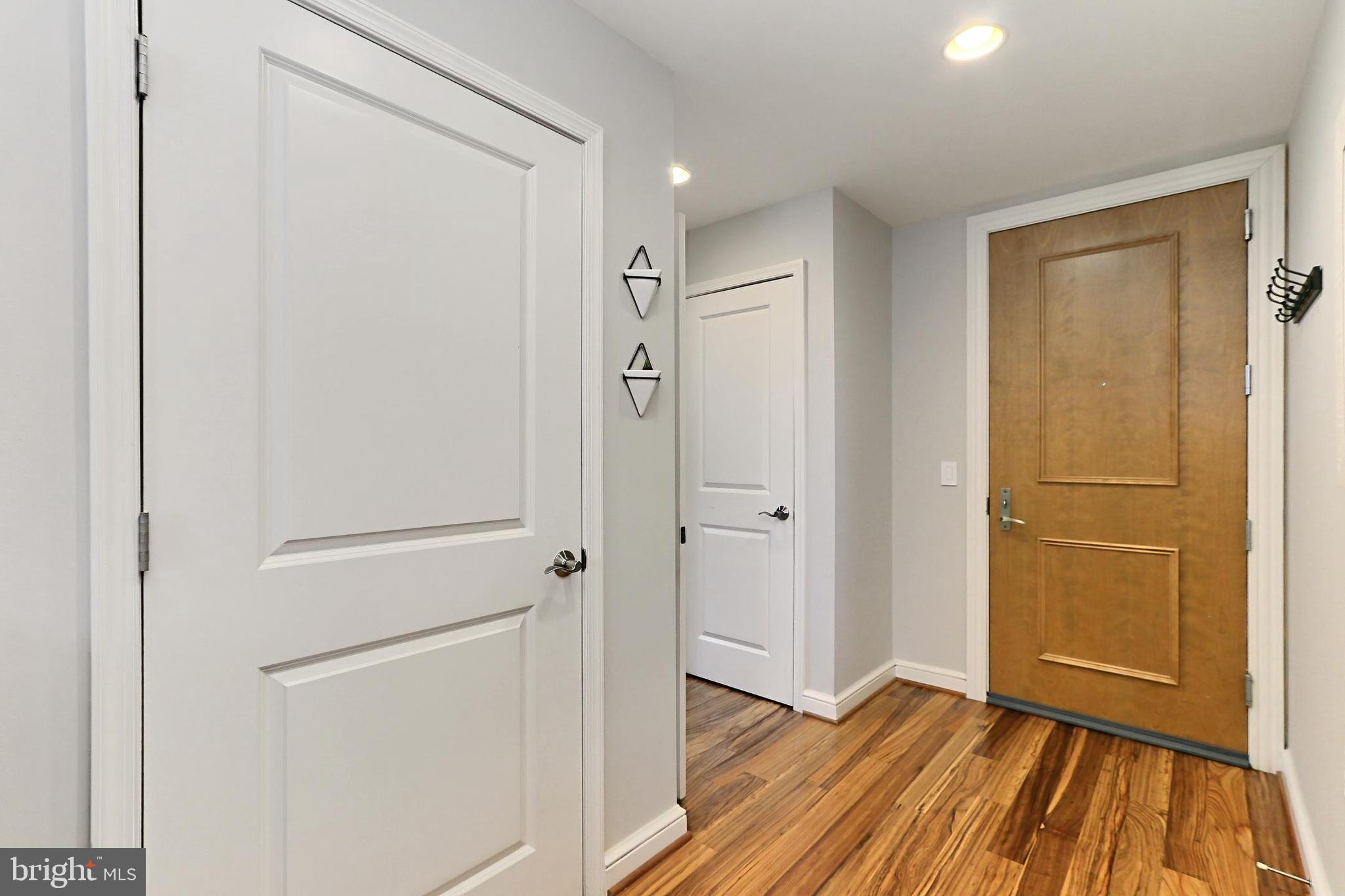 11990 Market Street, Unit 908 Reston, VA 20190 - Photo 3 of 45 a view of a hallway with wooden floor and closet area