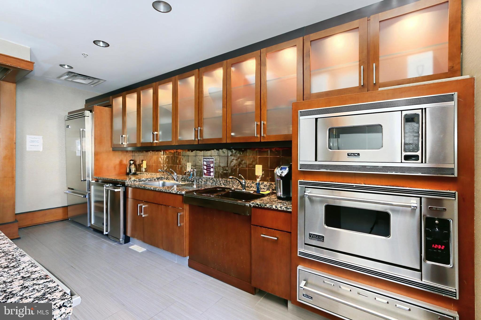 11990 Market Street, Unit 908 Reston, VA 20190 - Photo 35 of 45 a kitchen with stainless steel appliances granite countertop a stove and a microwave