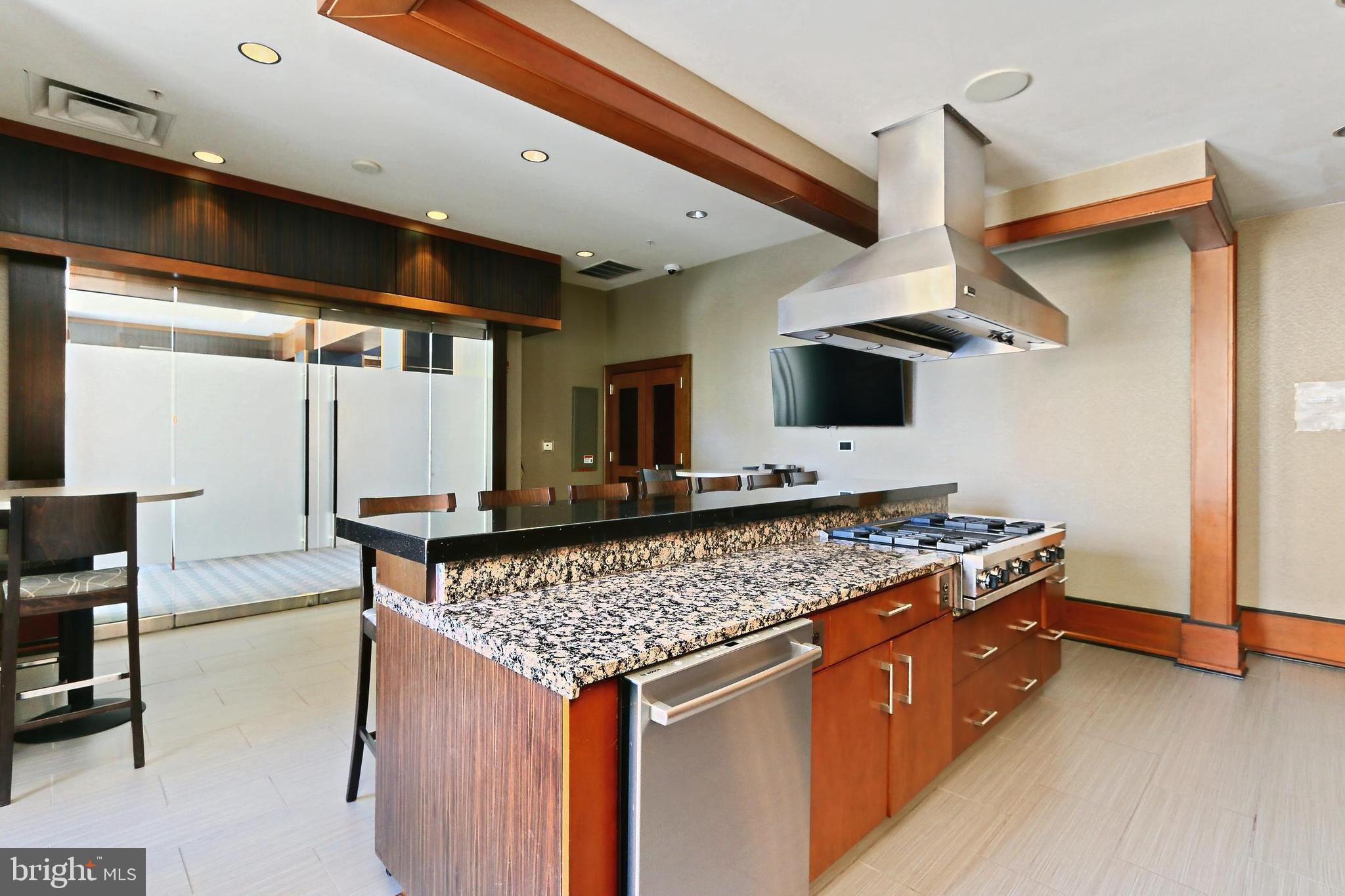 11990 Market Street, Unit 908 Reston, VA 20190 - Photo 36 of 45 a kitchen with stainless steel appliances granite countertop a stove and a wooden floor