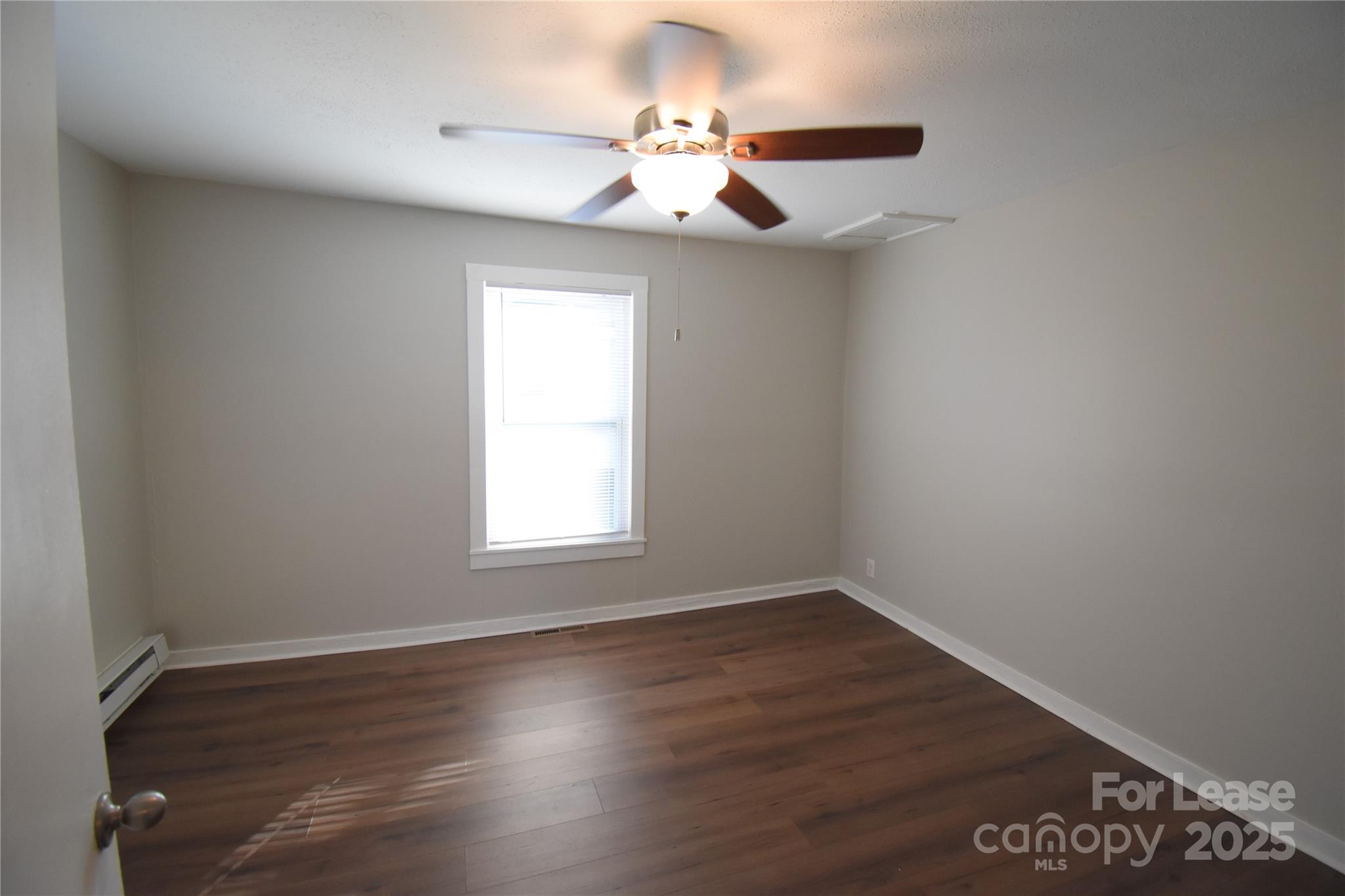337 Fox Street Southwest Concord, NC 28025 - Photo 12 of 16 an empty room with wooden floor chandelier fan and windows