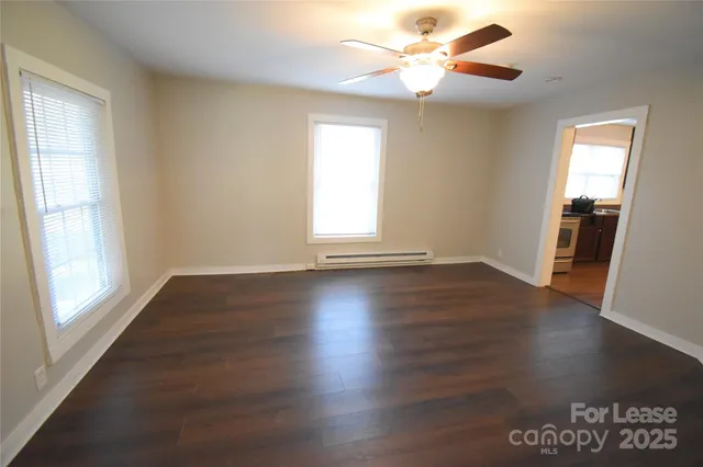 a view of a livingroom with wooden floor and a ceiling fan