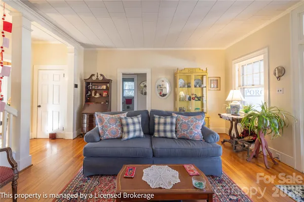 a living room with lots of furniture a chandelier and a book shelf