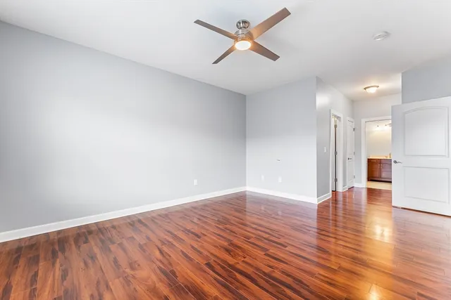 a view of a big room with wooden floor and windows
