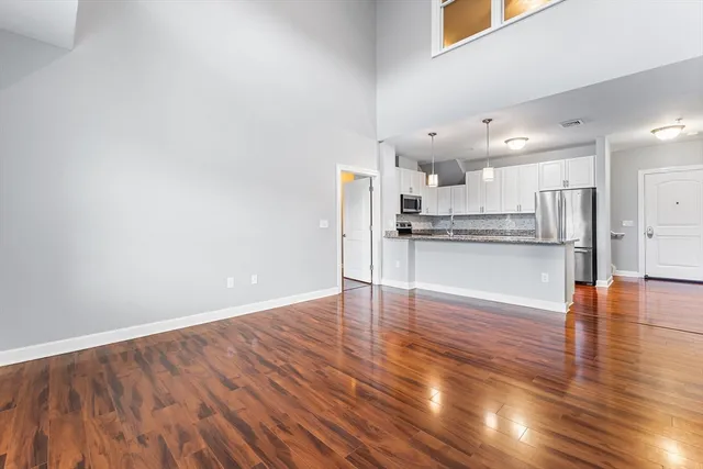 a view of a kitchen with wooden floor and electronic appliances