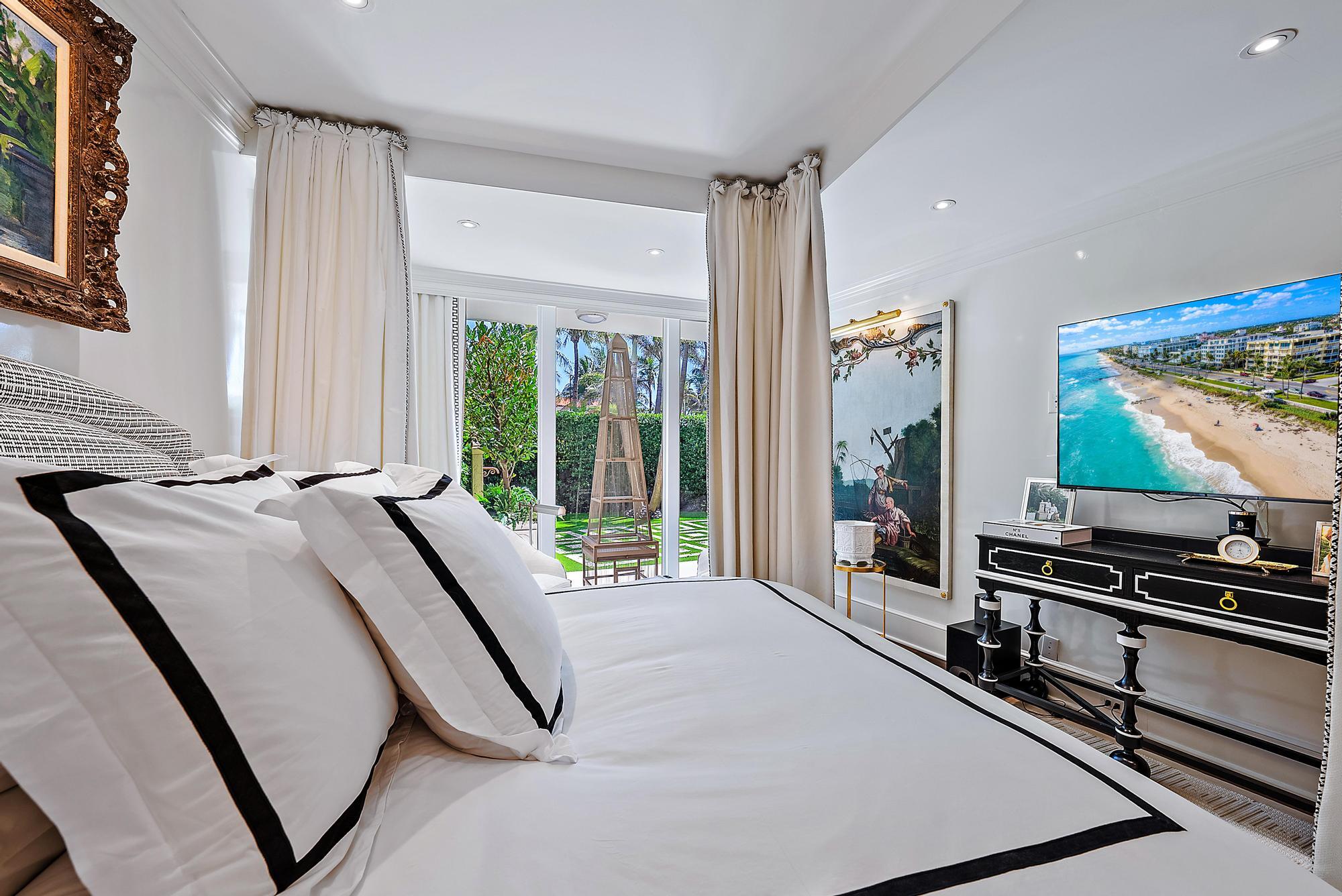 100 Royal Palm Way, Unit F1 Palm Beach, FL 33480 - Photo 22 of 43 a bedroom with a bed and a flat tv screen on dresser