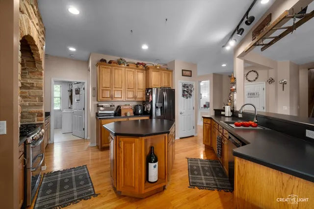 a kitchen with stainless steel appliances granite countertop a refrigerator and a stove