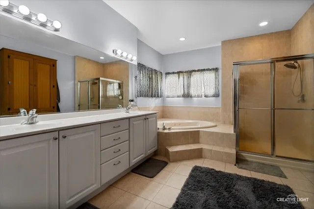 a spacious bathroom with a tub sink and mirror
