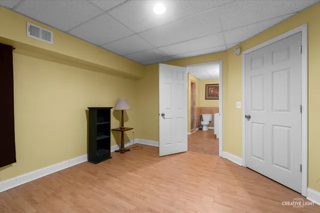 a view of empty room with wooden floor and cabinet