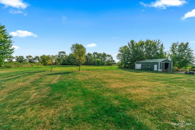 a view of a big yard with a house in the background