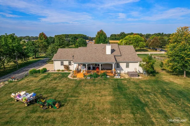 a view of a house with a big yard potted plants and large tree