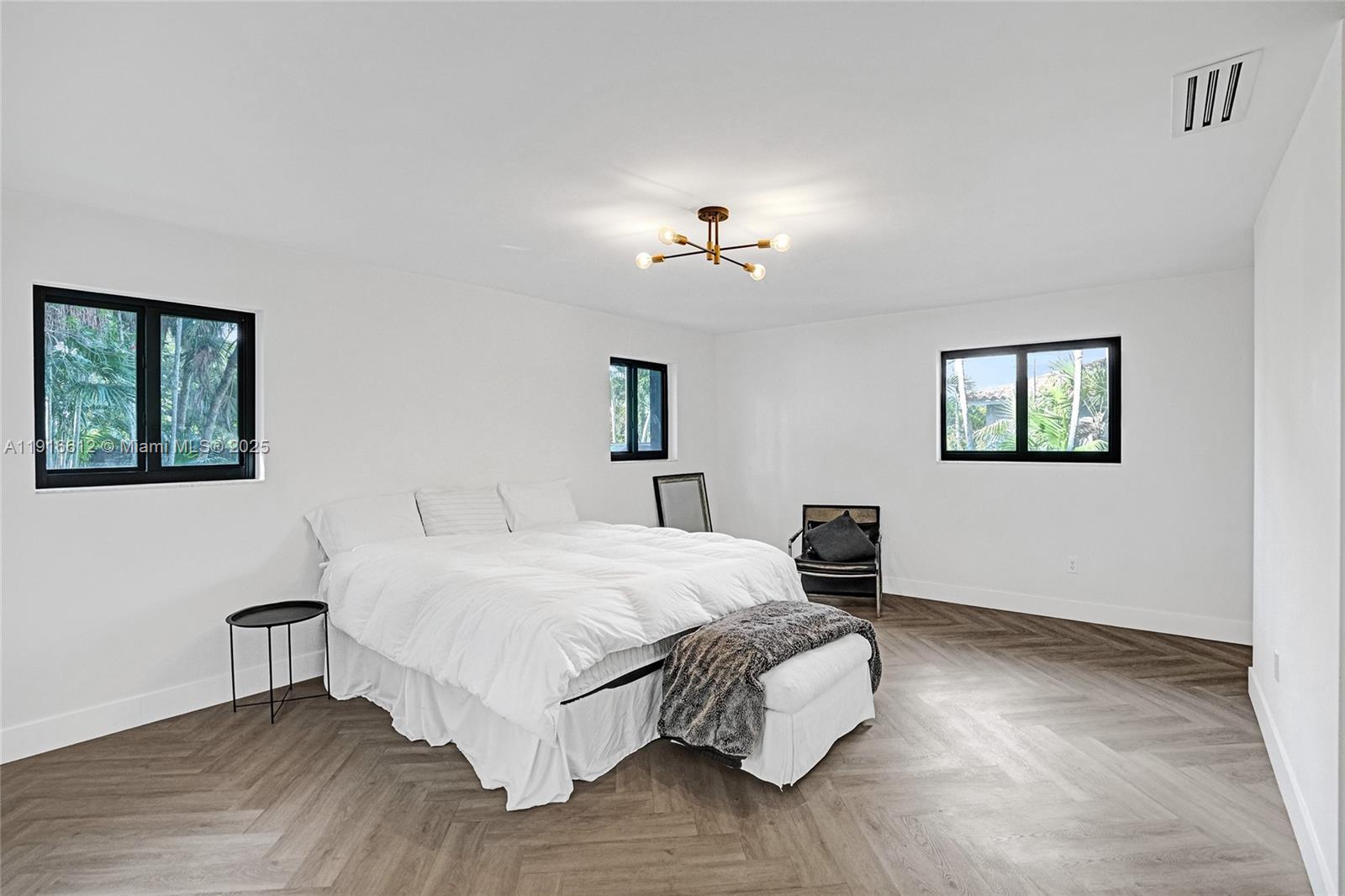 14135 North Miami Avenue Miami, FL 33168 - Photo 16 of 32 a bedroom with a bed and a chandelier