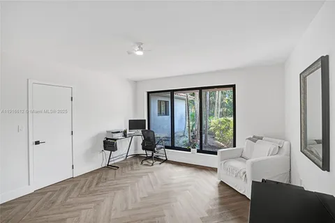 a living room with furniture and floor to ceiling window