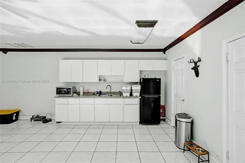 a living room with furniture a flat screen tv and kitchen view