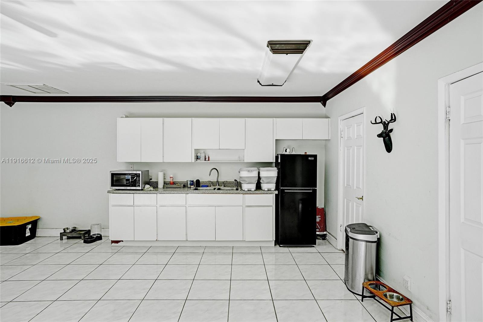 14135 North Miami Avenue Miami, FL 33168 - Photo 29 of 32 a kitchen with a refrigerator and cabinets