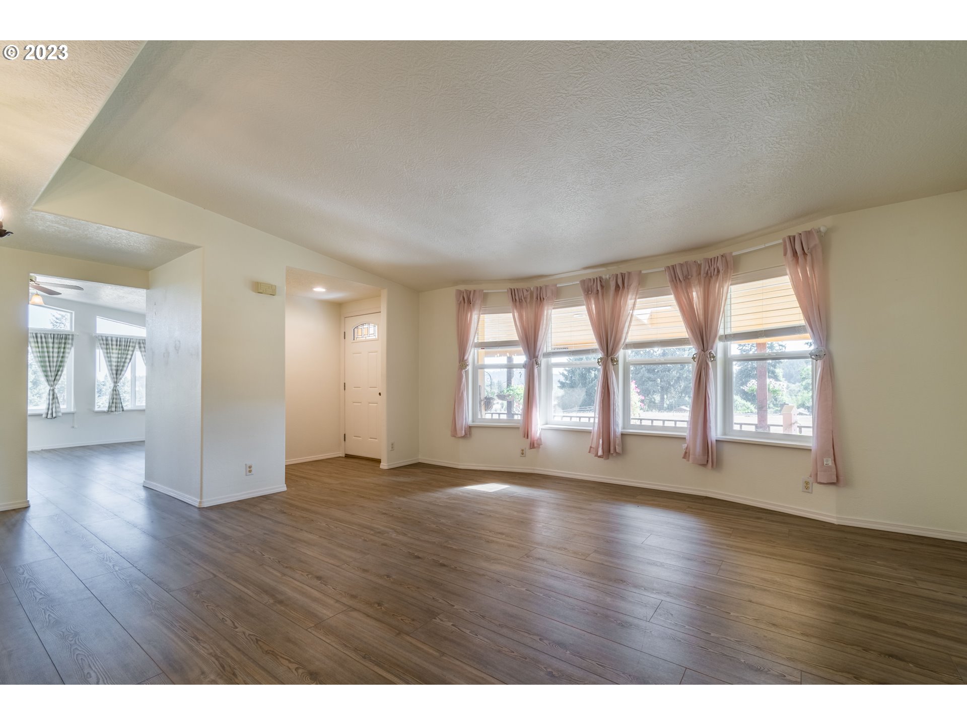 28485 Briggs Hill Road Eugene, OR 97405 - Photo 2 of 36 a view of an empty room with wooden floor and a window