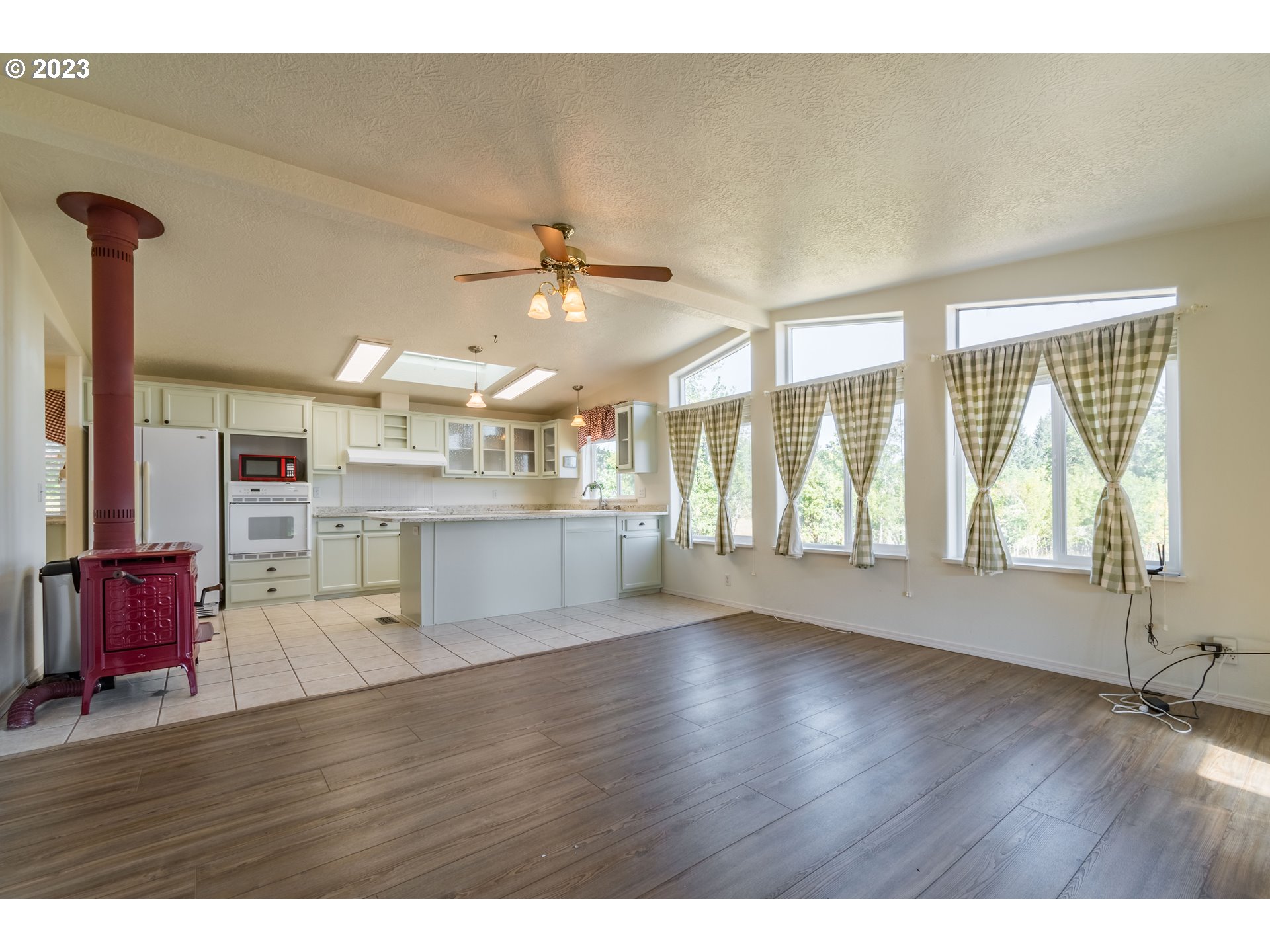28485 Briggs Hill Road Eugene, OR 97405 - Photo 7 of 36 a view of an empty room with wooden floor and a window