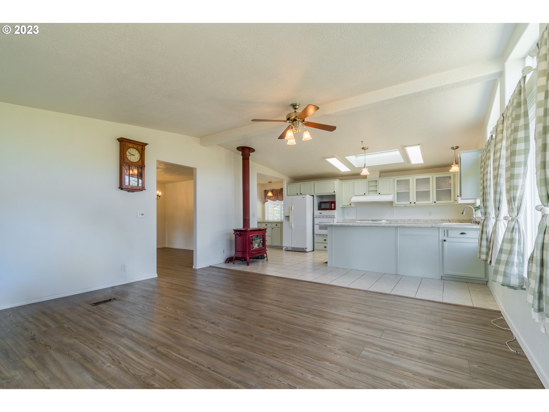 28485 Briggs Hill Road Eugene, OR 97405 - Photo 8 of 36 a view of a living room a kitchen with a sink and wooden floor