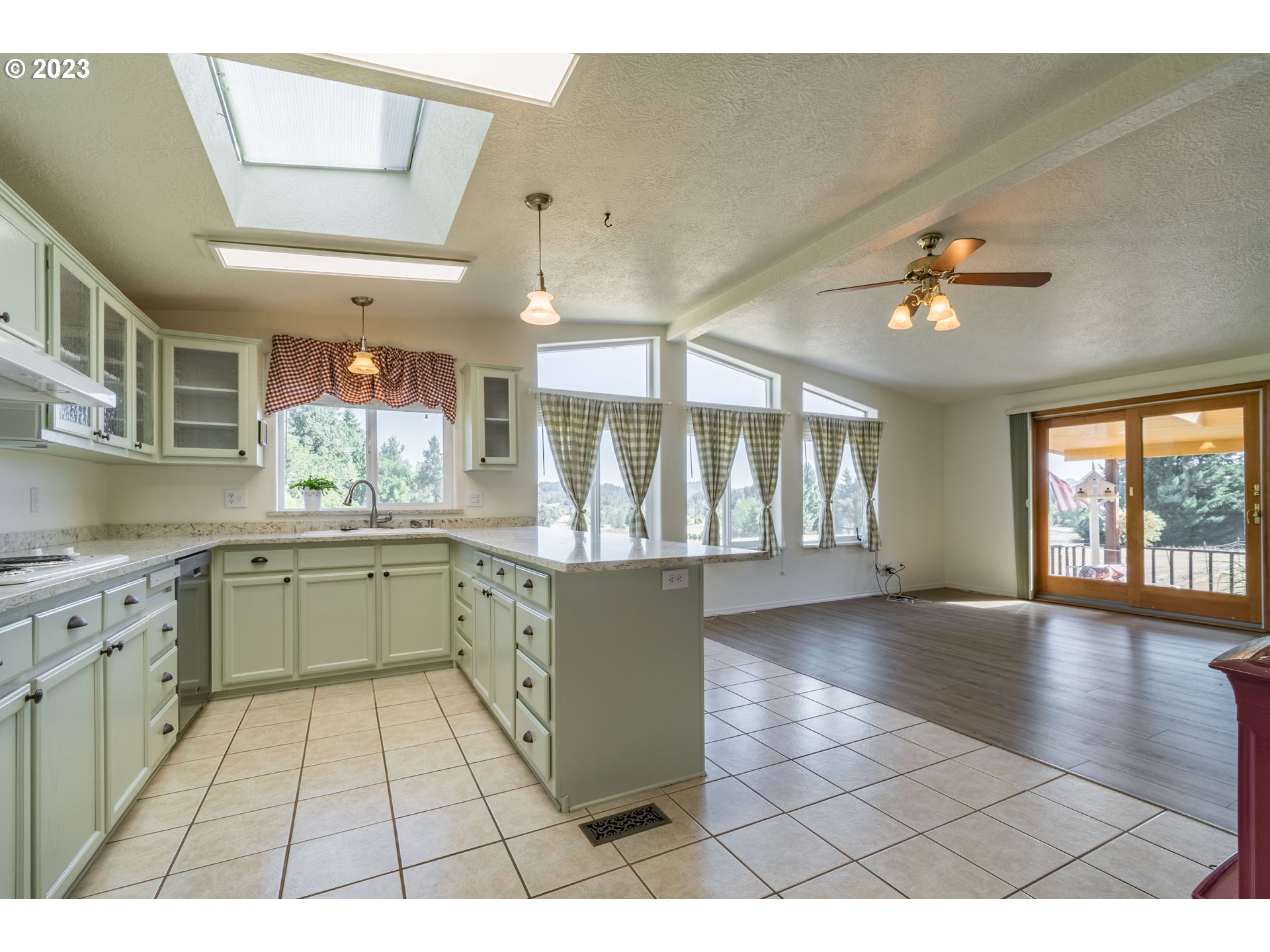 28485 Briggs Hill Road Eugene, OR 97405 - Photo 9 of 36 a open kitchen with stainless steel appliances granite countertop a stove a sink dishwasher and a fireplace with wooden floor