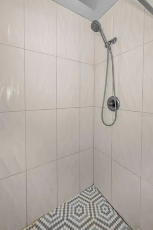 a bathroom with a sink a toilet a mirror and shower