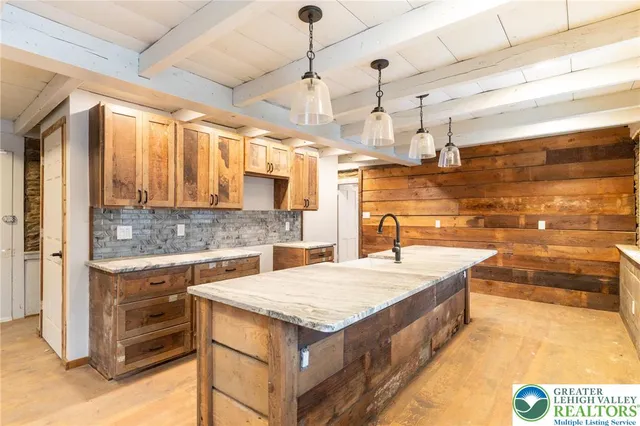a large kitchen with kitchen island a sink stove and wooden floor