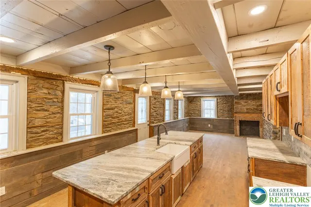 a view of an empty room with wooden floor and windows