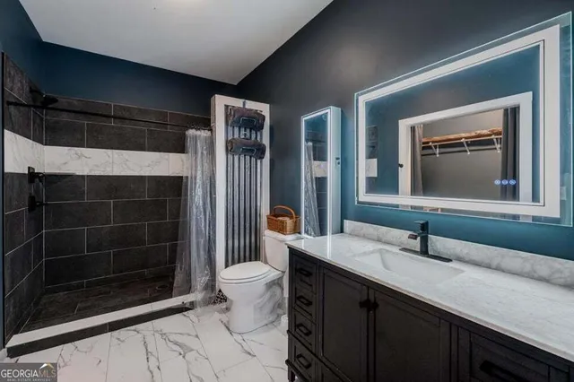 a bathroom with a sink a toilet and shower