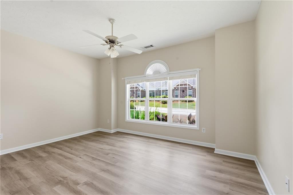 4533 Caleb Crossing, Unit 18 Powder Springs, GA 30127 - Photo 17 of 24 an empty room with wooden floor chandelier fan and windows