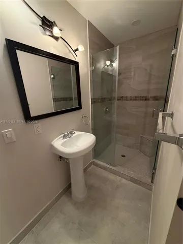 a bathroom with a sink mirror toilet and shower