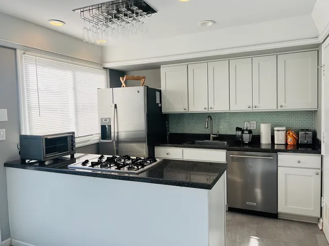 a kitchen with a refrigerator sink and cabinets
