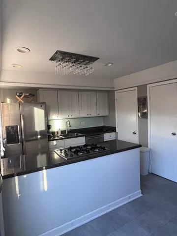 a kitchen with stainless steel appliances granite countertop a sink a stove and a refrigerator