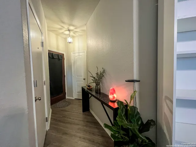 a view of a hallway with wooden floor and closet