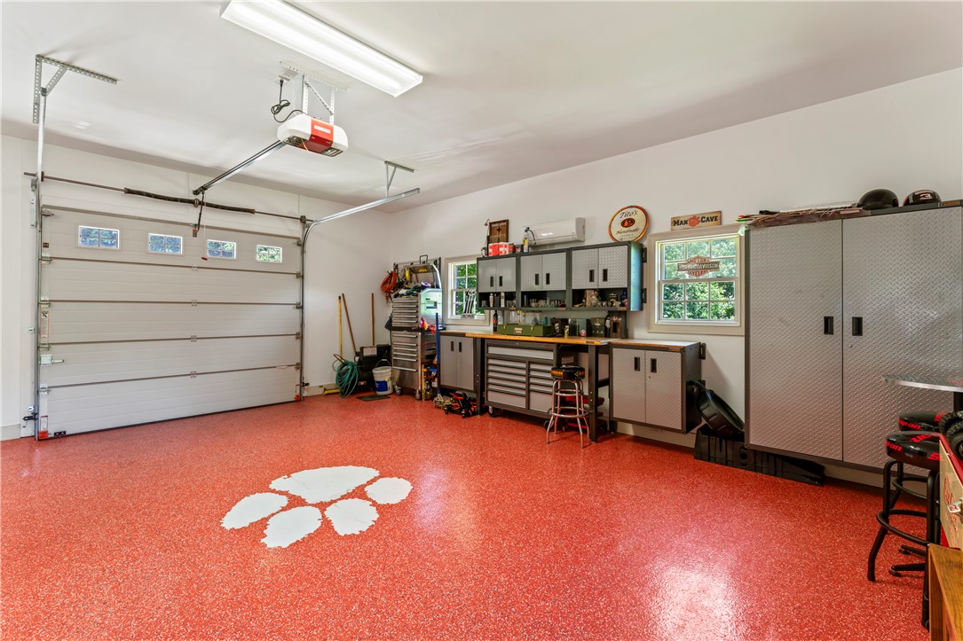 579 Terrapin Crossing Road Pickens, SC 29671 - Photo 33 of 50 A vibrant orange speckled floor welcomes you into this spacious garage, complete with an organized workshop area.