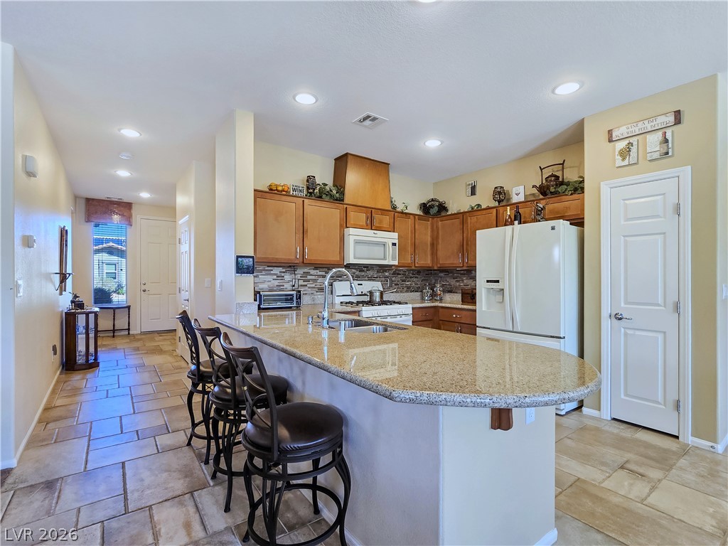 2485 Morrow Ridge Place Laughlin, NV 89029 - Photo 13 of 40 An inviting kitchen features a breakfast bar with granite counters, ideal for casual dining.
