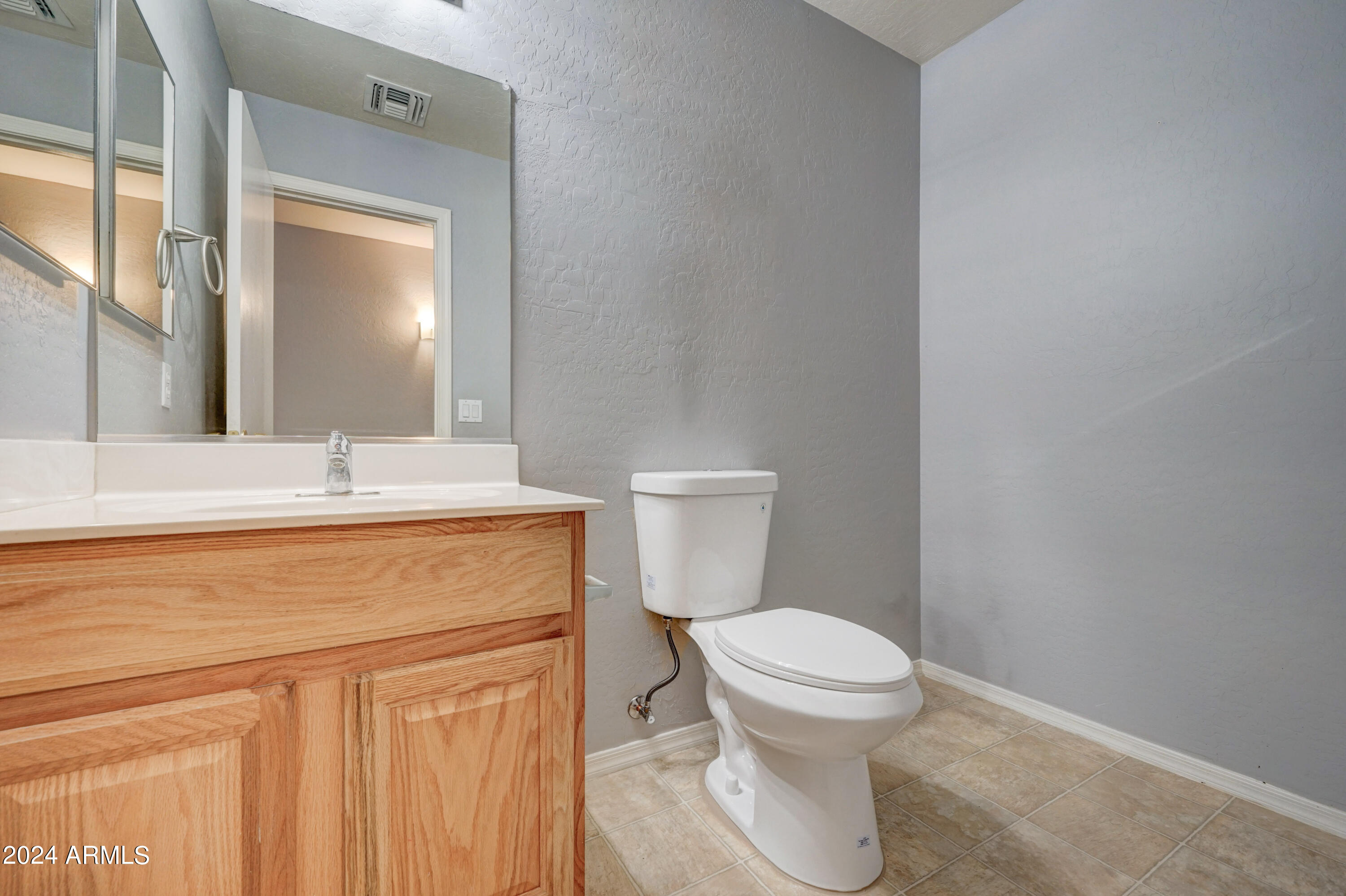 2554 West Tanner Ranch Road San Tan Valley, AZ 85144 - Photo 7 of 39 a bathroom with a toilet sink and mirror