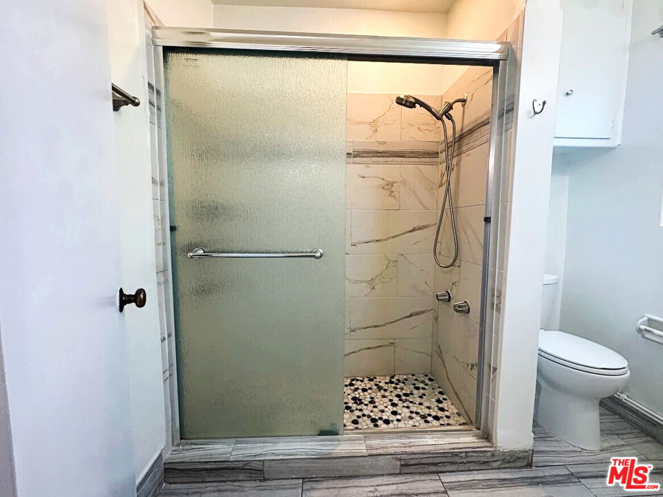 110 South Rampart Boulevard, Unit 3 Los Angeles, CA 90057 - Photo 12 of 17 a bathroom with a glass shower door and a toilet