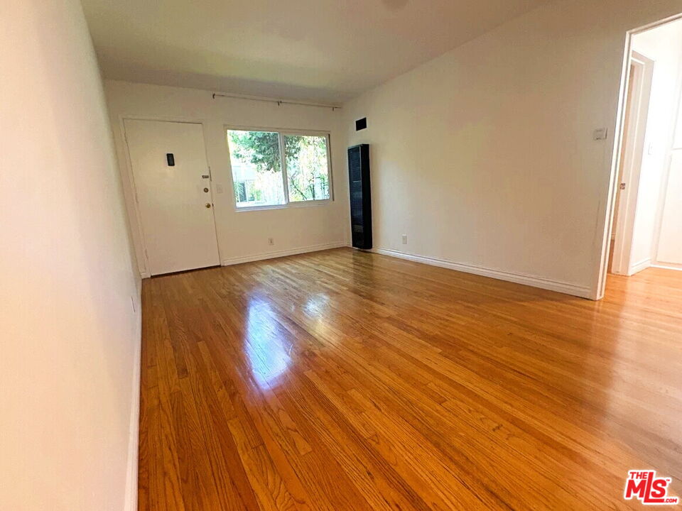 110 South Rampart Boulevard, Unit 3 Los Angeles, CA 90057 - Photo 3 of 17 a view of an empty room with wooden floor and a window