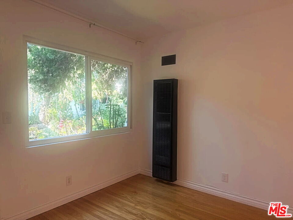 110 South Rampart Boulevard, Unit 3 Los Angeles, CA 90057 - Photo 4 of 17 a view of an empty room with wooden floor and a window