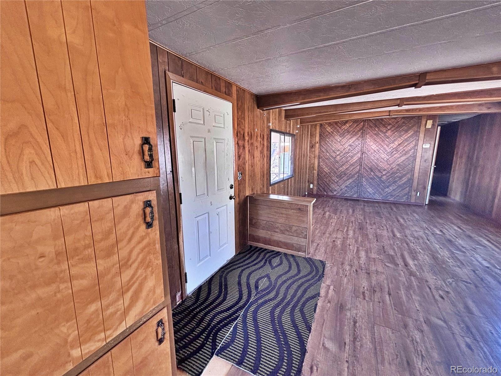 1114 Reed Lane La Junta, CO 81050 - Photo 12 of 22 a view of front door with wooden floor and stairs
