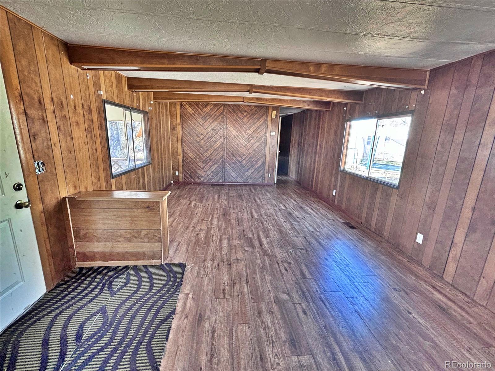 1114 Reed Lane La Junta, CO 81050 - Photo 13 of 22 a view of an empty room with wooden floor and a window