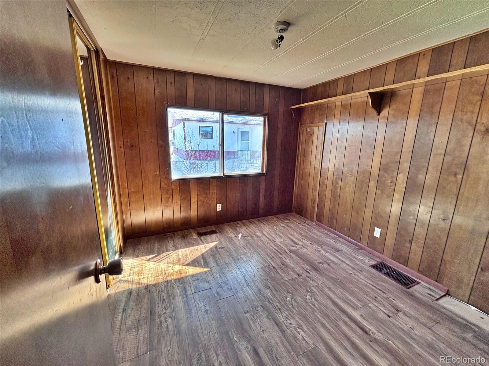 1114 Reed Lane La Junta, CO 81050 - Photo 16 of 22 a view of an empty room with wooden floor and a window