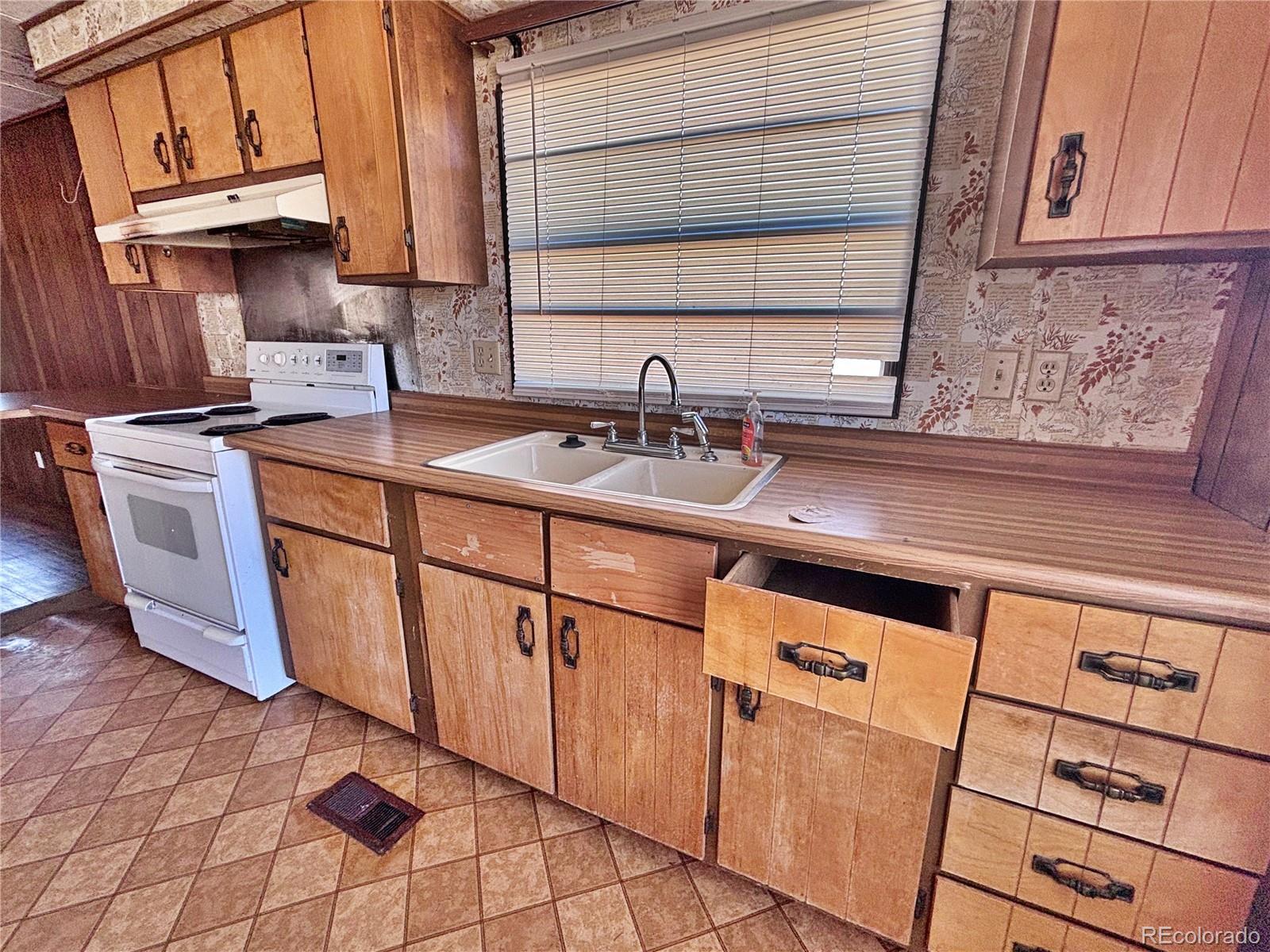 1114 Reed Lane La Junta, CO 81050 - Photo 10 of 22 a kitchen with stainless steel appliances granite countertop a sink stove and cabinets