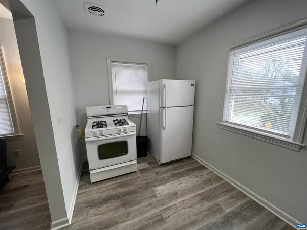 a kitchen with a stove a refrigerator and a window