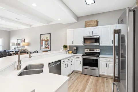 a kitchen with white cabinets and stainless steel appliances