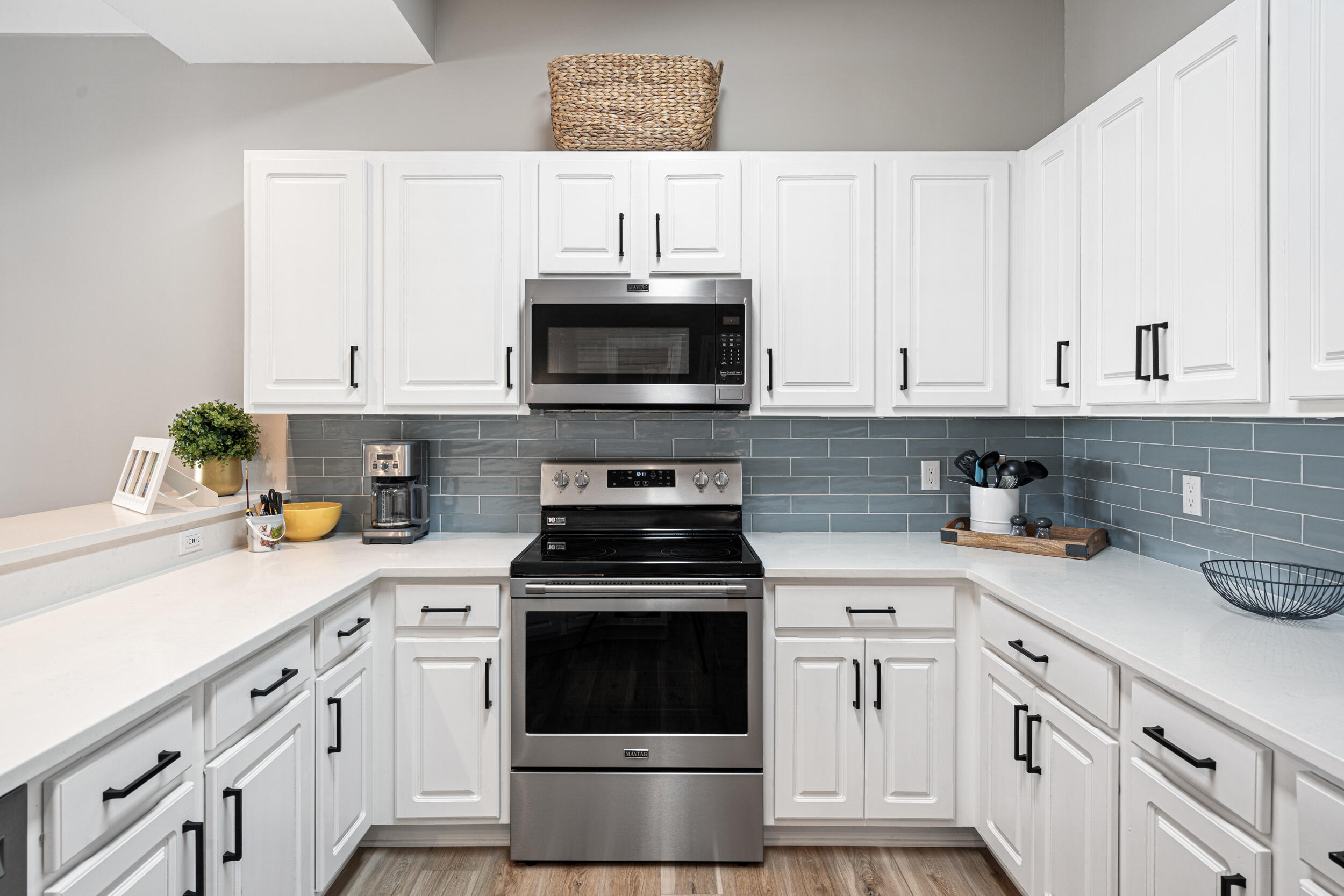 2410 Scenic Gulf Drive, Unit 201C Miramar Beach, FL 32550 - Photo 13 of 39 a kitchen with white cabinets and appliances