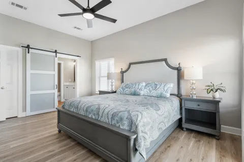 a bedroom with a bed and a table with wooden floor