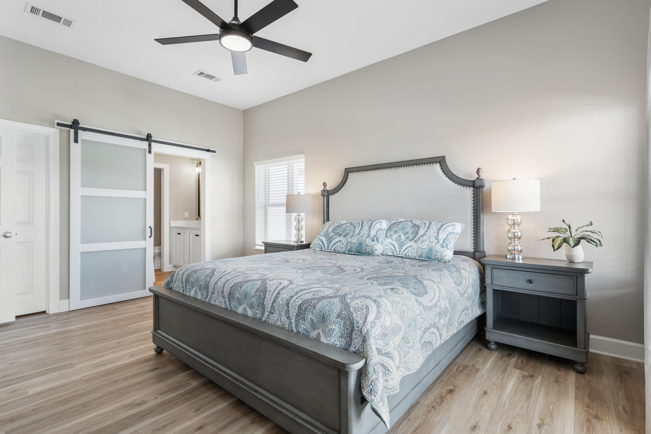 2410 Scenic Gulf Drive, Unit 201C Miramar Beach, FL 32550 - Photo 18 of 39 a bedroom with a bed and a table with wooden floor