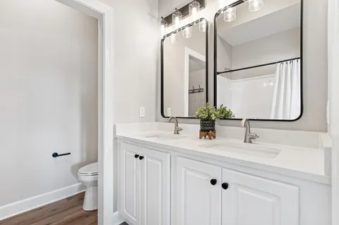 a bathroom with a double vanity sink and a mirror