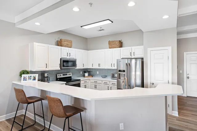 a kitchen with stainless steel appliances a refrigerator and a stove top oven