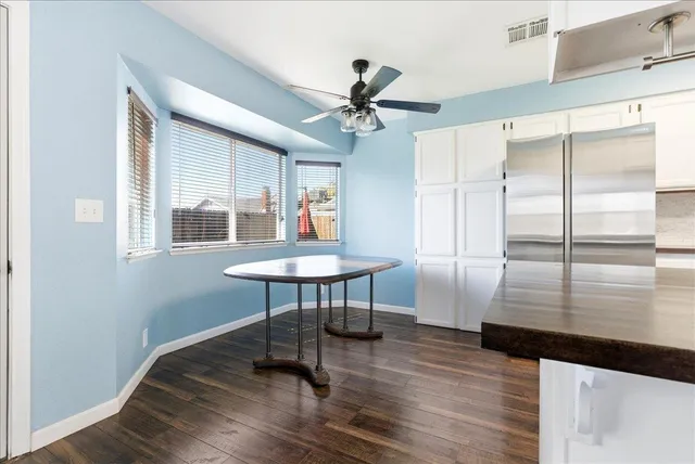a view of a livingroom with furniture a ceiling fan and wooden floor